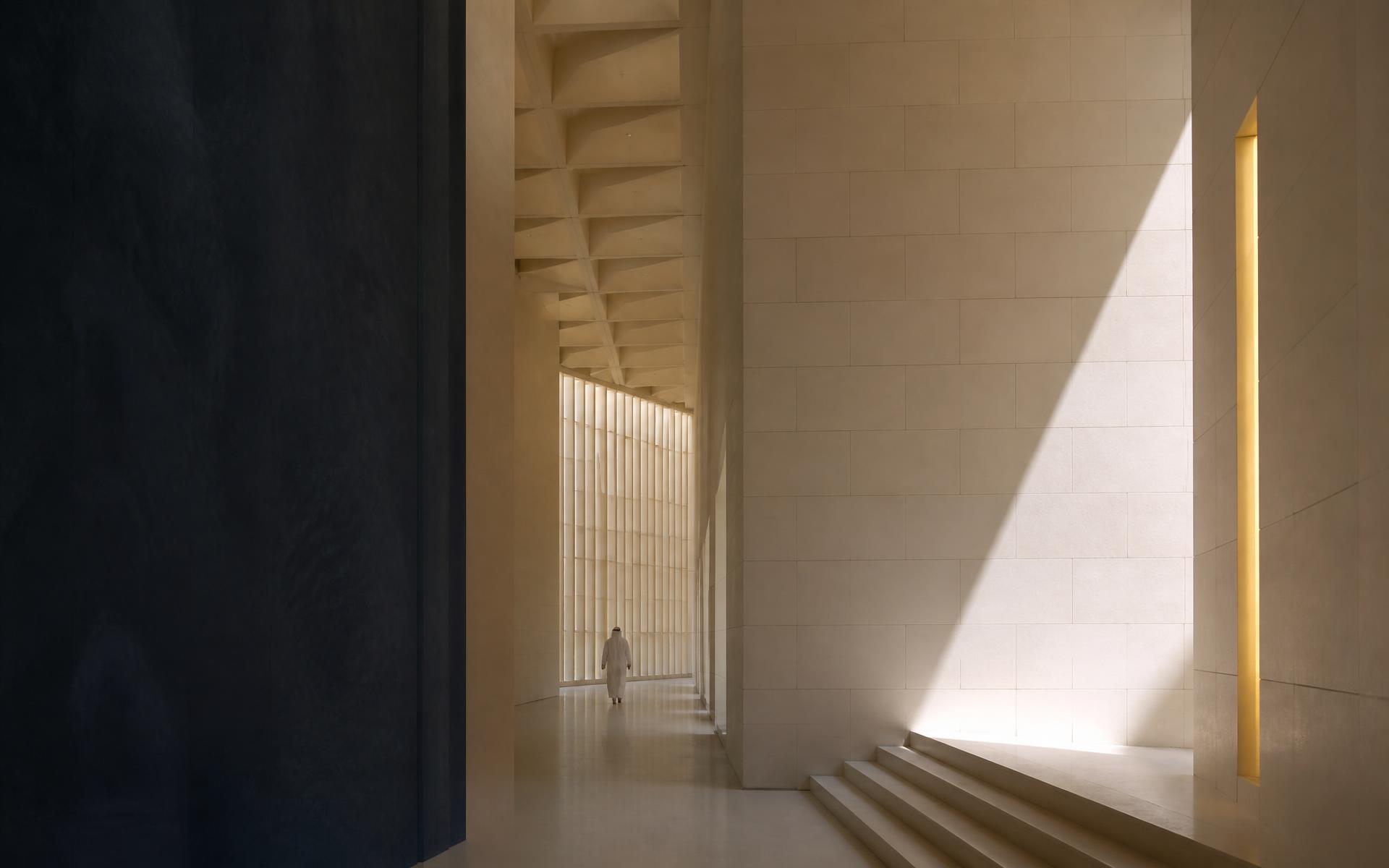 Sunlit stone corridor of a contemporary institutional building